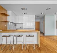 A kitchen in a 3-room apartment with a wooden bar counter and stools.