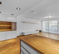 A living room in a three-room apartment with wooden flooring and built-in wardrobes.
