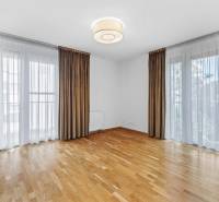 Spacious living room in a 3-room apartment with wooden flooring and large windows.