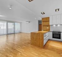 The bright kitchen with wooden flooring in the 3-room apartment has a spacious design.