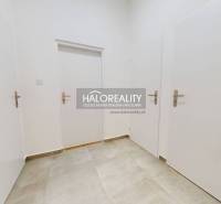 In the picture, there is a white door in an office space with a tiled floor.