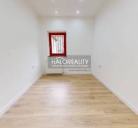 An empty office space with wooden flooring and white walls.
