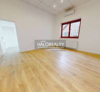 A bright room with laminate flooring and a large window in office spaces.