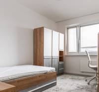 A room in a 3-room apartment with a bed, a wardrobe, and a desk with a chair.