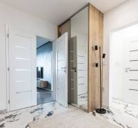 Hallway in a 3-room apartment with white doors and a large mirror.