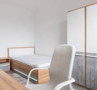 A bedroom with a bed, a cabinet, and a wardrobe in a three-room apartment.