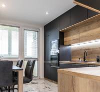 A kitchen with wooden elements and a modern dining table in a 3-room apartment.