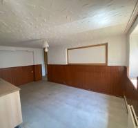 Interior of a room with wooden paneling and a kitchenette. Apartment construction.