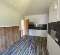 A room with wooden paneling and tiles on the wall, apartment construction.