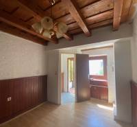 Construction of apartments with wooden paneling, light walls, and a ceiling with beams.