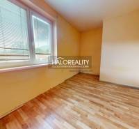 A room with a large window and wooden floor in a 3-room apartment.