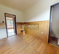 A room in a 3-room apartment with wooden paneling and empty walls for renovation.