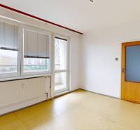 Bright room in a two-room apartment with a balcony, wooden floor, and built-in blinds.