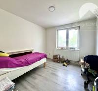 A room in a family house with a single bed and a large window.