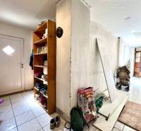 The entrance hall of the family house with a shoe cabinet and storage items on the floor.