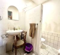 Bathroom in a family house with a mirror, sink, and toilet.