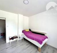A bedroom with a single bed, wooden floor, minimalist furnishings of a family house.