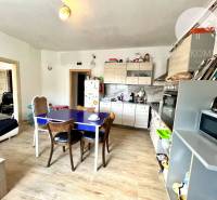 A kitchen in a family house with a dining table and built-in appliances.