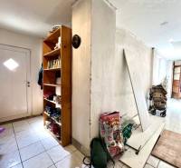 Hallway in a family house with a shelf for books and shoes.