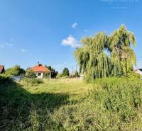 Plots - housing in Moča, Okoč with a view of the grassy area and houses in the background.