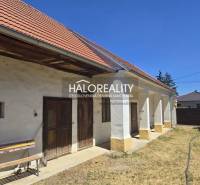 A family house in Váhovce with a white facade, wooden doors, and a gabled roof.