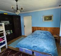 Blue room with a bunk bed, double bed, and dark wardrobe in a family house.
