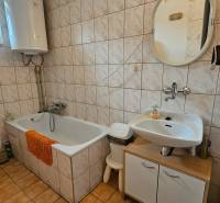 Bathroom in a family house with a bathtub, sink, and toilet.