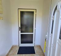 Entrance hallway in a family house with tiles and white doors.