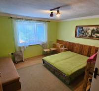 Bedroom in a family house with a bed, wardrobe, and a picture on the wall.