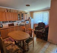 A kitchen in a family house with a wooden cabinet and a dining table.