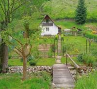 A cottage in Malá Lodina on Ružín Street with a landscaped garden in a natural setting.