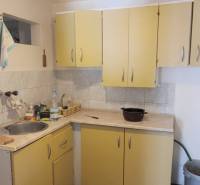 A kitchen in a cottage with double-door cabinets, a sink, and a gas connection.