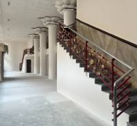Interior of commercial premises with a spiral staircase and decorative columns.