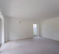 An empty room with large windows in a 2-room apartment ready to be furnished.