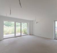 Bright empty room with large windows in a 2-room apartment.