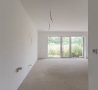 Unfurnished room with large windows in a 2-room apartment, view of greenery.
