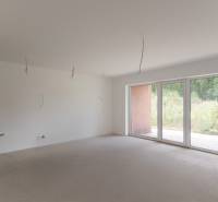 Empty room in a 2-room apartment with panoramic windows and a view of greenery.