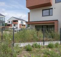 The exterior of the apartment complex on Javorová Street in Kostolište with a fence and greenery.
