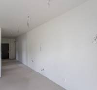 An unfurnished room in a 2-room apartment with white walls and cables.