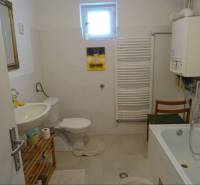 Bathroom of a family house with a bathtub, sink, toilet, and mirror.