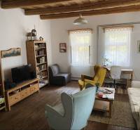 Living room in a family house with a library and a wooden ceiling, furnished with comfortable furniture.