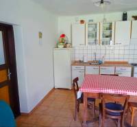 A kitchen in a family house with a table and a checkered tablecloth, a simple and cozy space.