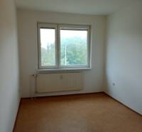 A room with a window and a radiator in a 3-room apartment with simple lighting.