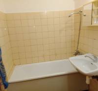 Bathroom in a 3-room apartment with a bathtub, sink, and tiles.