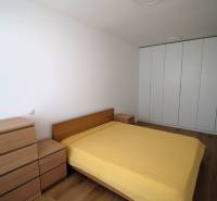 Bedroom in a 2-room apartment with a double bed and a large built-in wardrobe.