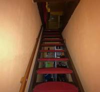 Stairs with red carpets in the interior of a family house with orange walls.