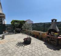 There is a terrace with a grill and flowers in the exterior of the 2-room apartment in Nitra.