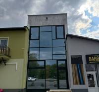Commercial premises in Poprad with modern large glass windows under a cloudy sky.