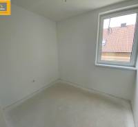 Empty room in a 5 or more bedroom apartment with white walls and a window.