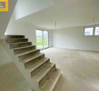 Interior of a 5 or more bedroom apartment with a concrete staircase and spacious living area.